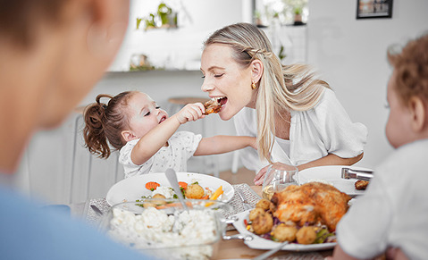 Enfant donne à manger du poulet à sa maman avec les mains