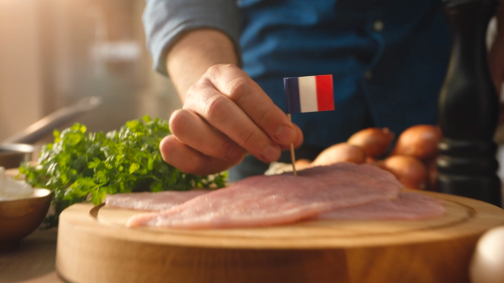 Homme qui plante un drapeau français dans une escalope de poulet